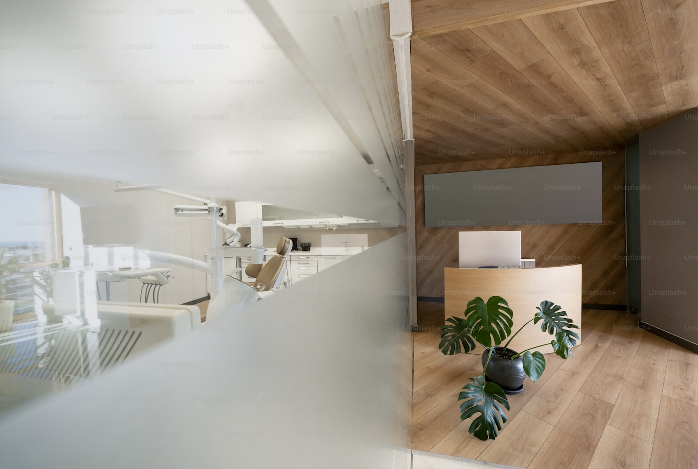 Interior moderno e acolhedor da recepção da clínica, com madeira clara e plantas